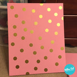 Gold polka dot stickers on a painted canvas
